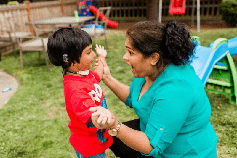 Nurse for critical babies in teal shirt with child.