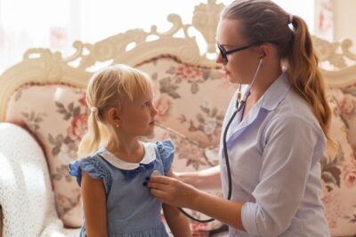 a healthcare provider checking the vital signs of a girl