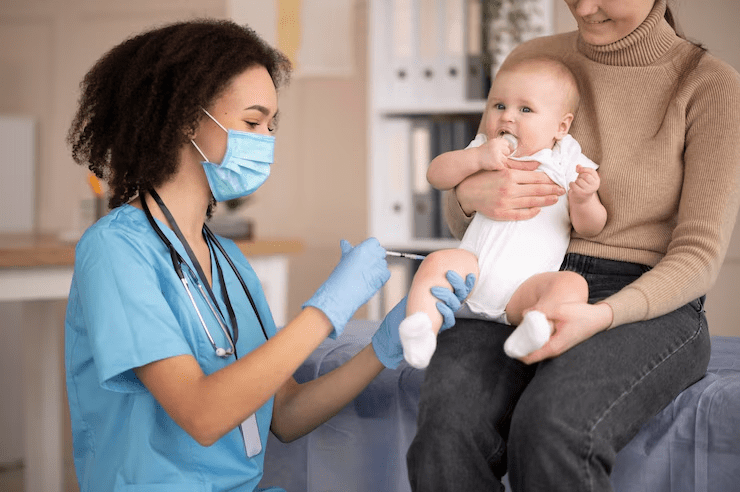 A nursing assistant applying medicine to a baby.